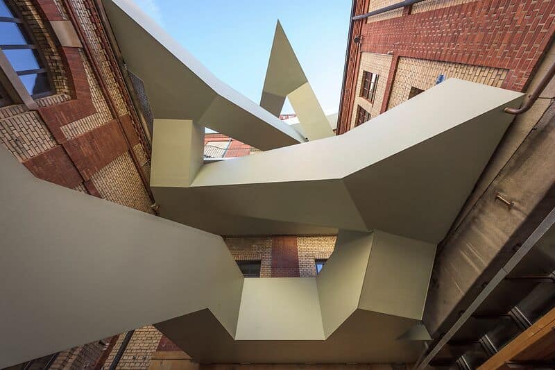 Die markante Aussentreppe an der ehemaligen Bierbrauerei Warteck erschliesst Räume für Kultur, Kunst, Handwerk und Gastronomie. /// The distinctive exterior staircase at the former Warteck brewery provides access to spaces for culture, art, crafts, and dining.